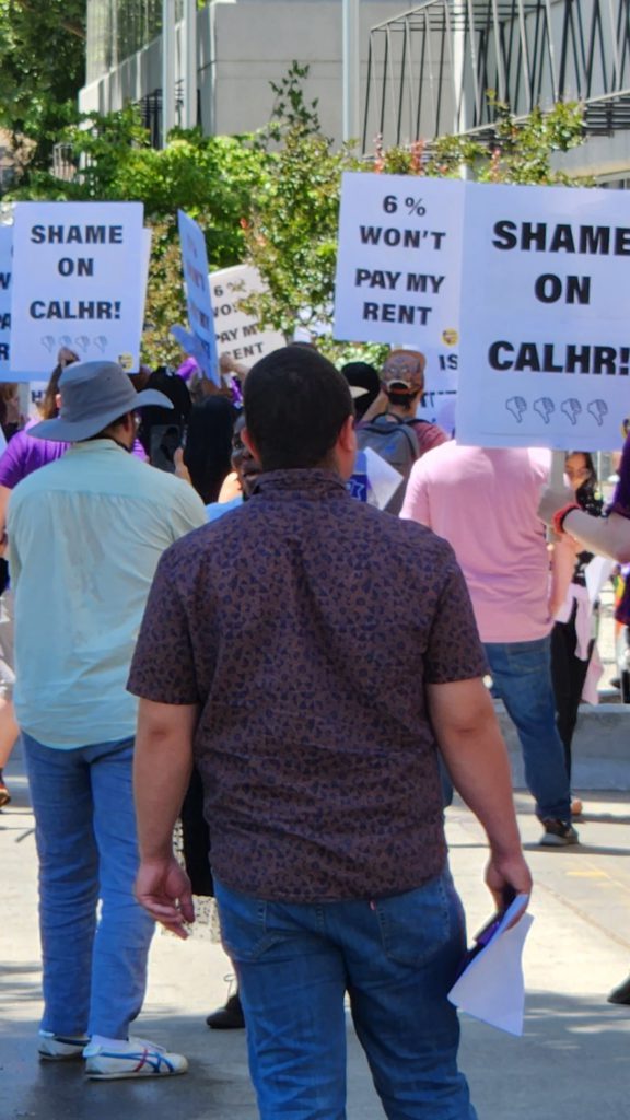 Protest signs that say "6% won't pay my rent" and "Shame on CalHR"